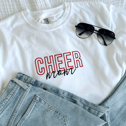 white Cheer Mom sports shirt with jeans and sunglasses