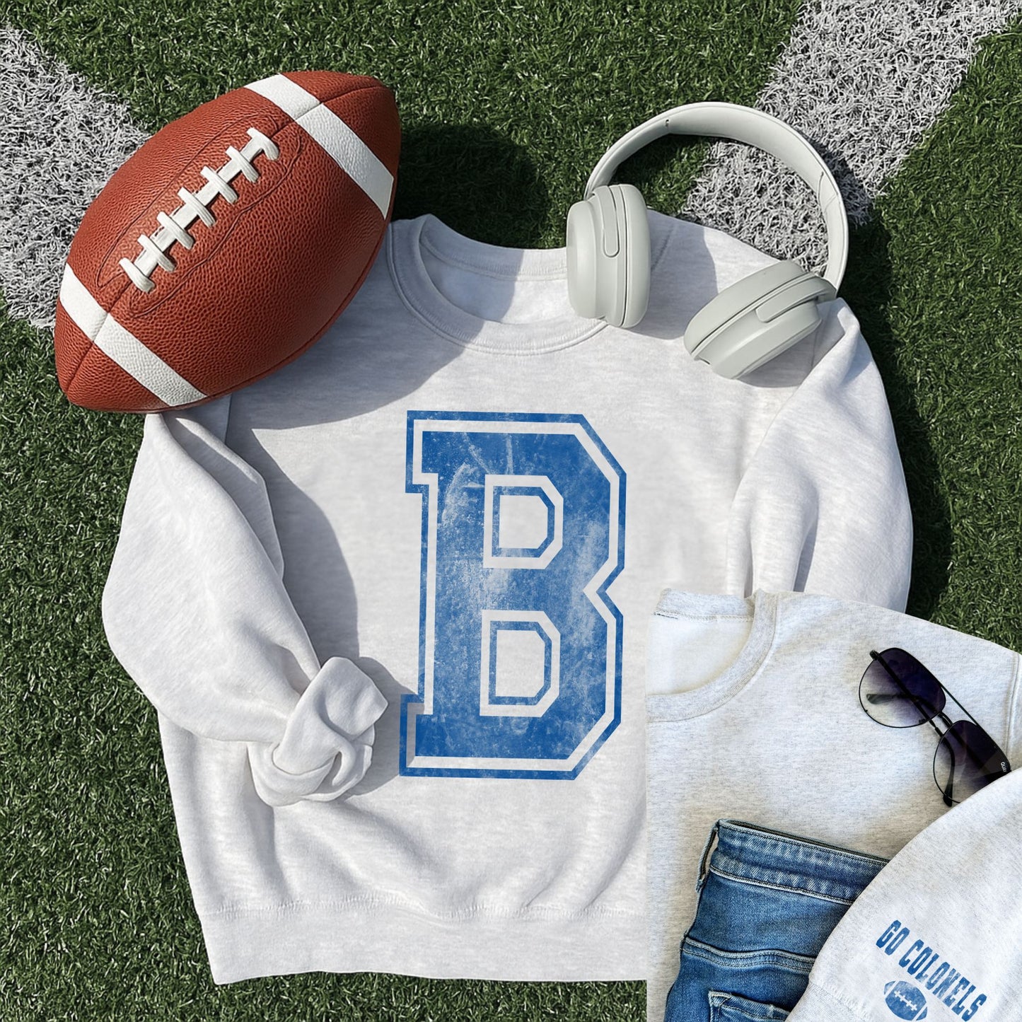 ash crewneck sweatshirt with printed distressed varsity inspired B in blue ink and another small outfit layout featuring an ash crewneck with go colonels and a football printed on the left sleeve cuff