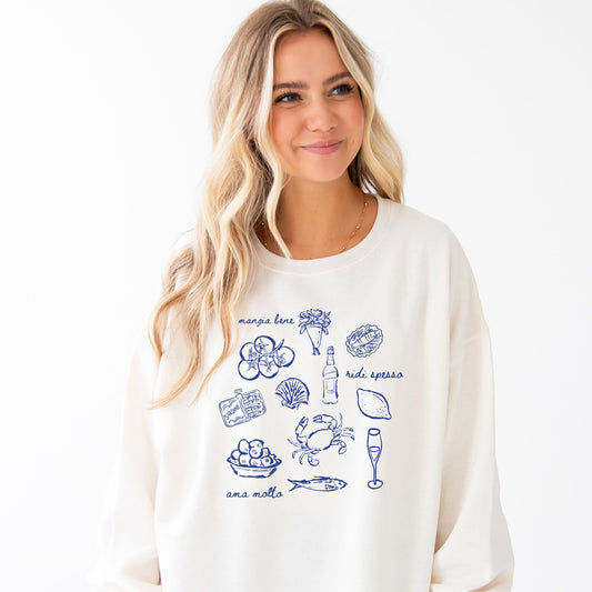 girl wearing a sweet cream crewneck sweatshirt with a printed design featuring an italian "mangia bene, ridi spesso, ama molto" and hand-drawn looking icons such as tomatoes, sardines, crab, olives, wine, and flowers