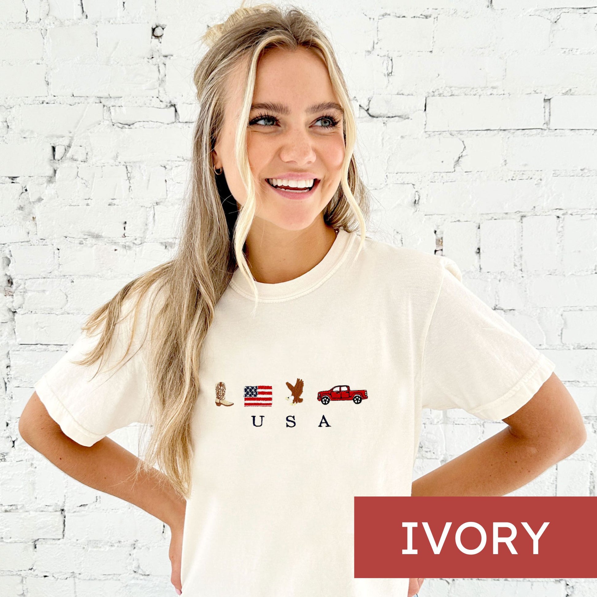 woman wearing an ivory comfort colors t-shirt with cute embroidered usa icons and usa design