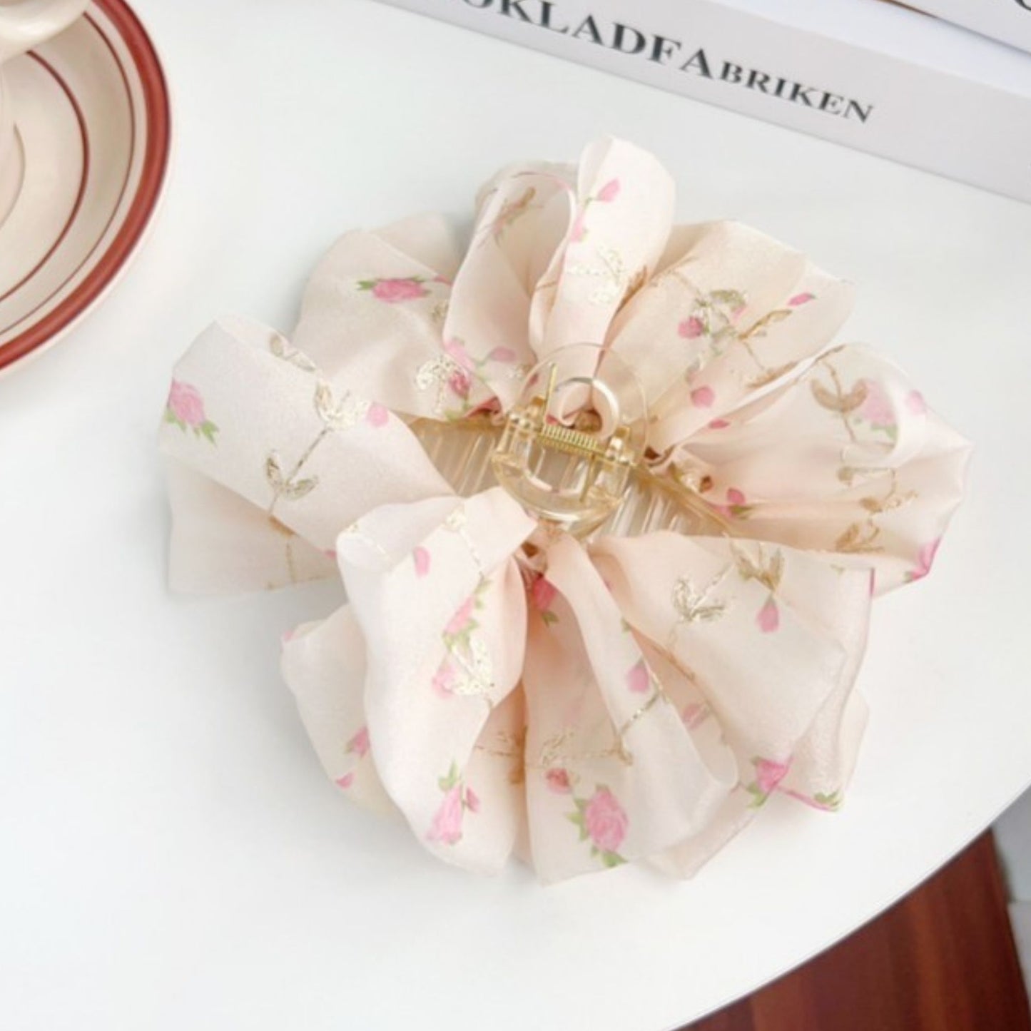 Floral scrunchie hair clip on a white surface