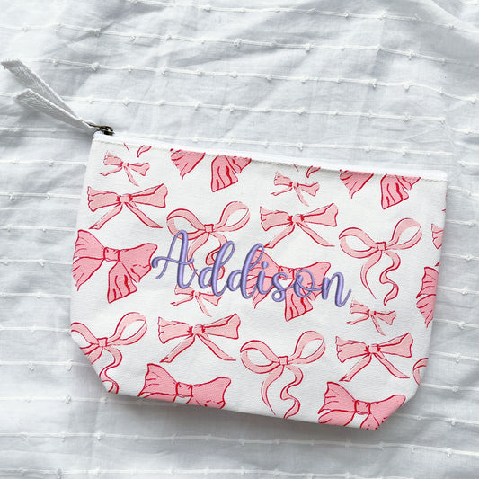 bow cosmetic pouch with custom name embroidery in purple thread
