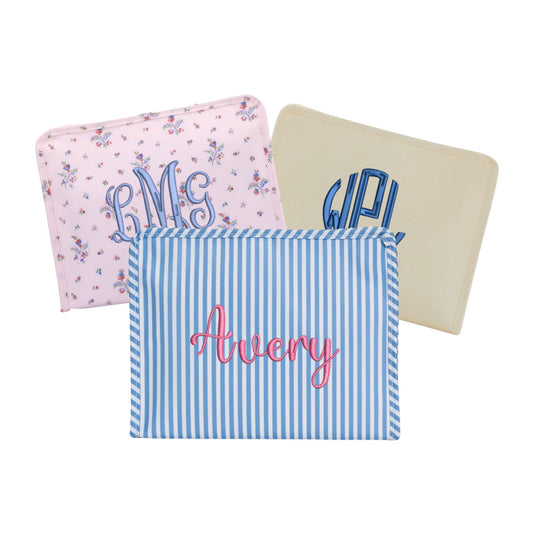 a floral patterned, natural, and blue stripe travel pouches with custom name and monogram embroidery in a variety of fonts and thread colors