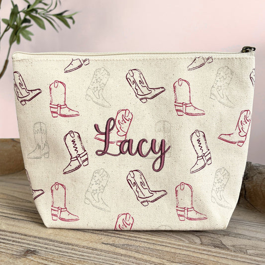 makeup pouch with cowgirl boot print on a natural cotton canvas featuring a custom name embroidery in burgundy thread