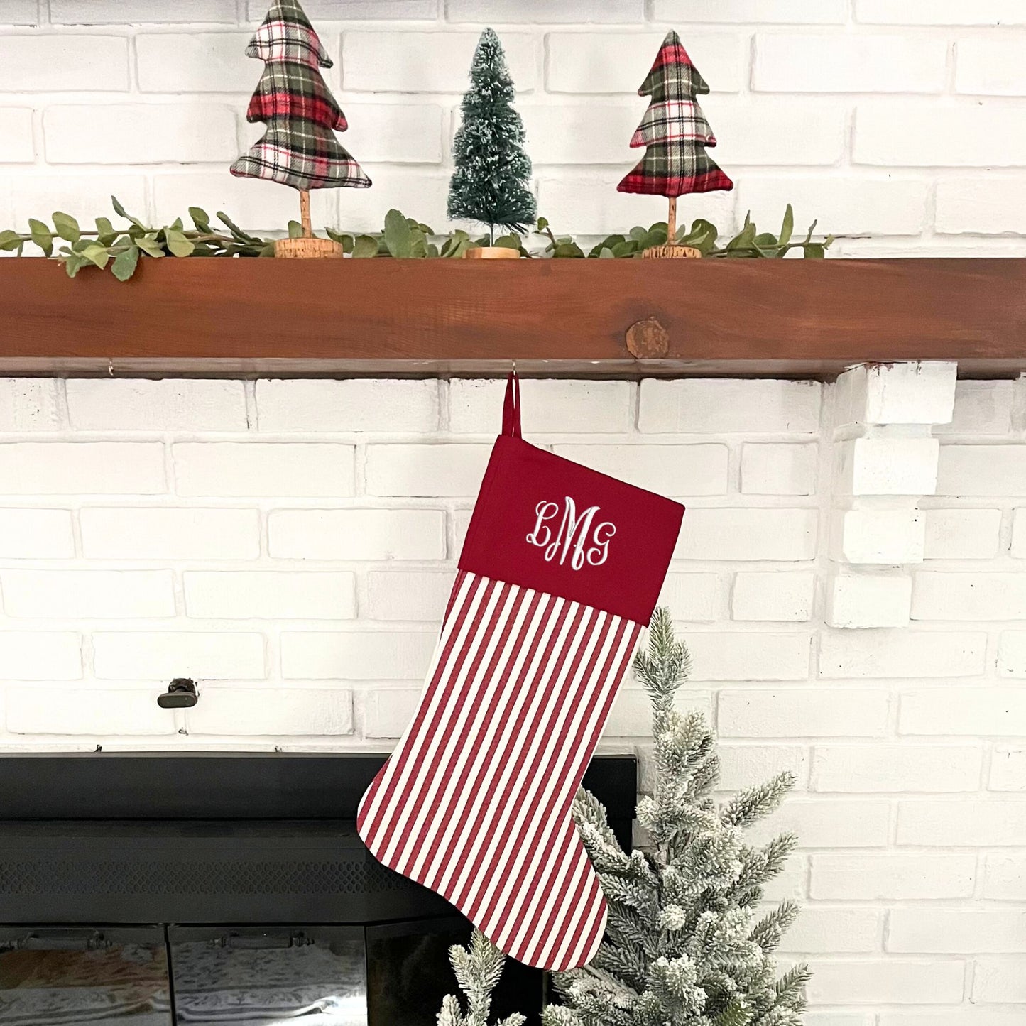 red and white striped stocking with custom embroidered monogram in white thread