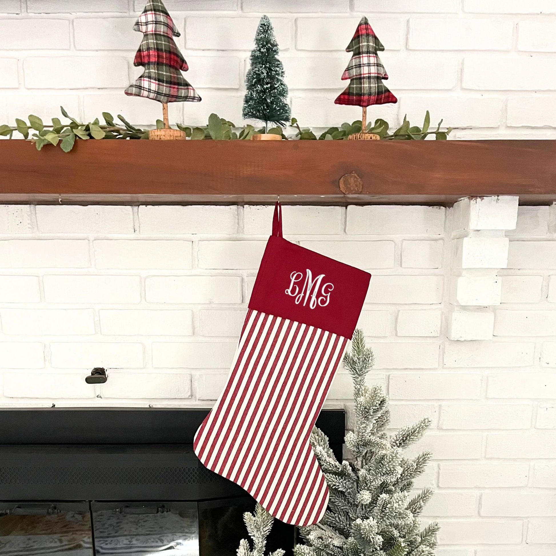 red and white striped stocking with custom embroidered monogram in white thread