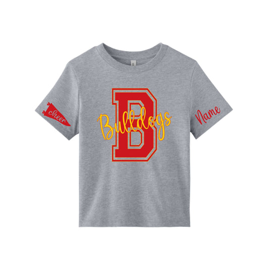 A kids' heather gray short-sleeve t-shirt featuring a large red and yellow 'B Bulldogs' graphic on the front, with a red 'Cheer' pennant on the left sleeve and 'Name' text on the right sleeve, shown on a plain white background.