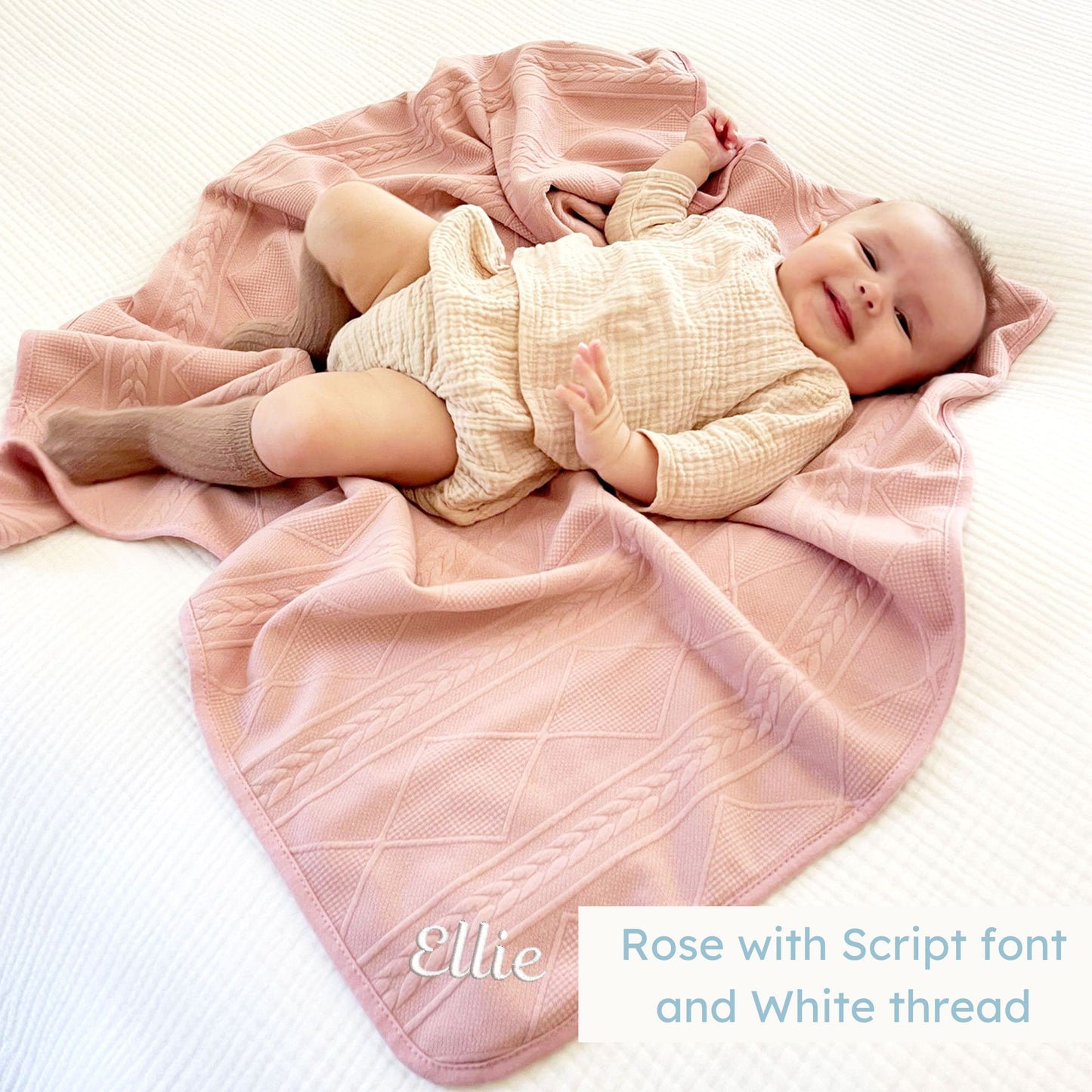 baby girl laying on a rose pink knitted blanket with a personalized name embroidered on the corner
