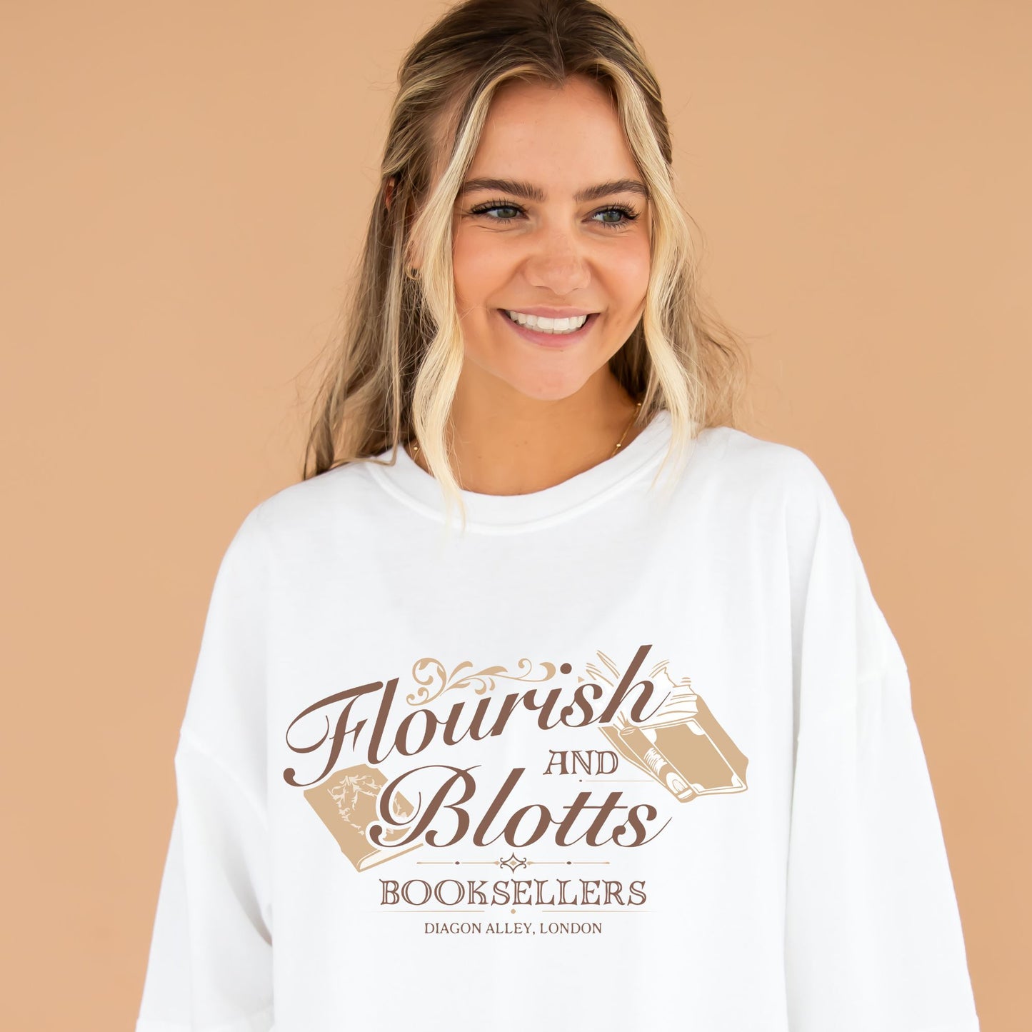 girl wearing an oversized white comfort colors t-shirt with a Flourish and Blotts booksellers printed design