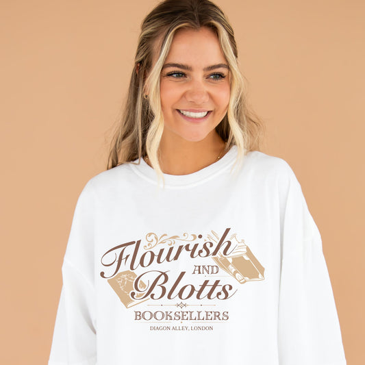 girl wearing an oversized white comfort colors t-shirt with a Flourish and Blotts booksellers printed design