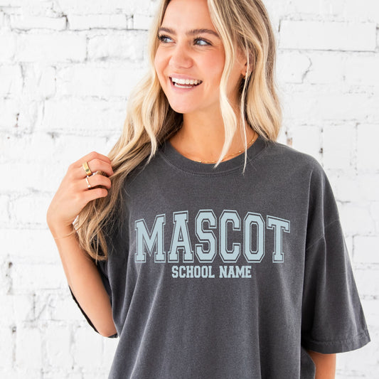 woman wearing an xl pepper comfort colors tee with a custom school mascot printed design in a powder blue ink