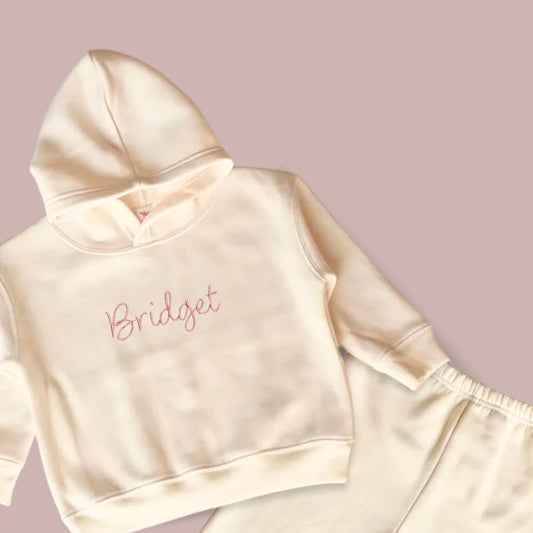 natural toddler hooded sweatshirt and jogger set with custom name embroidered in blithe font and coral pink thread