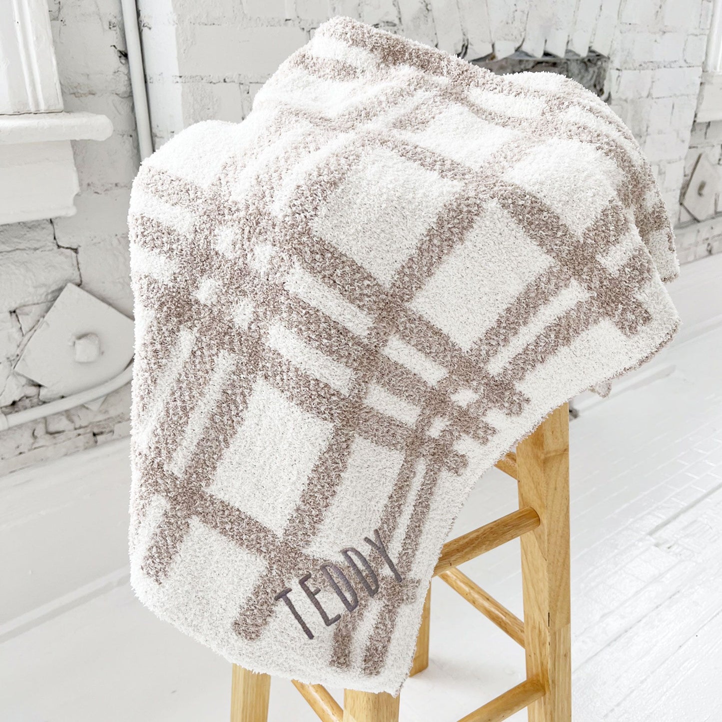 ultra soft cream and tan plaid baby blanket with custom name embroidered on the corner in Handicraft font and gray thread