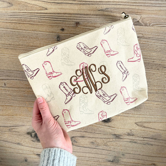 makeup pouch with cowgirl boot print on a natural cotton canvas featuring a custom monogram embroidery in chestnut thread