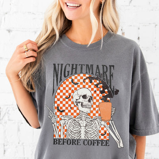 girl wearing a gray comfort colors t-shirt with a nightmare before coffee skeleton/bat print with a checkered background