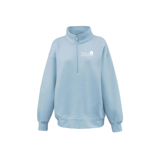 A light blue half-zip sweatshirt with a mock neck collar, featuring a small white 'VILLA' logo embroidered on the left chest, displayed on a clean white background.