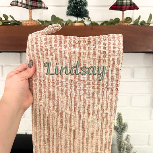 blush, natural, and gold striped stocking with custom name embroidered in script font and eucalyptus thread