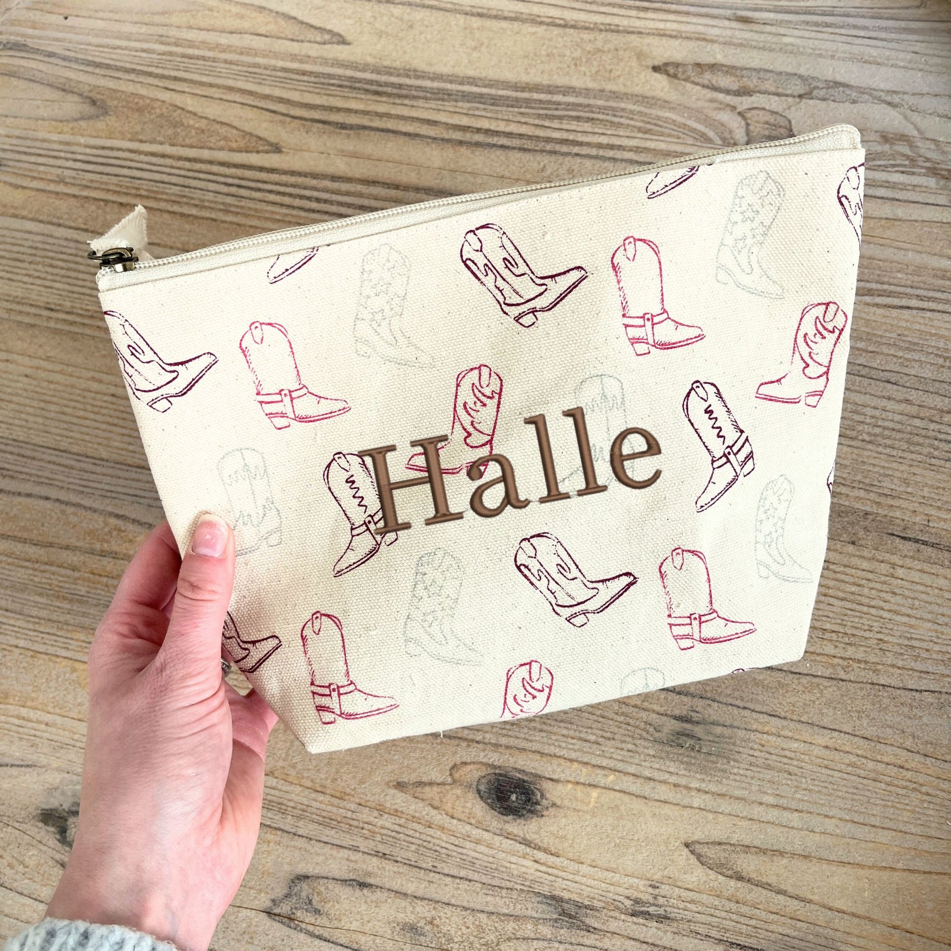 makeup pouch with cowgirl boot print on a natural cotton canvas featuring a custom name embroidery in chestnut thread