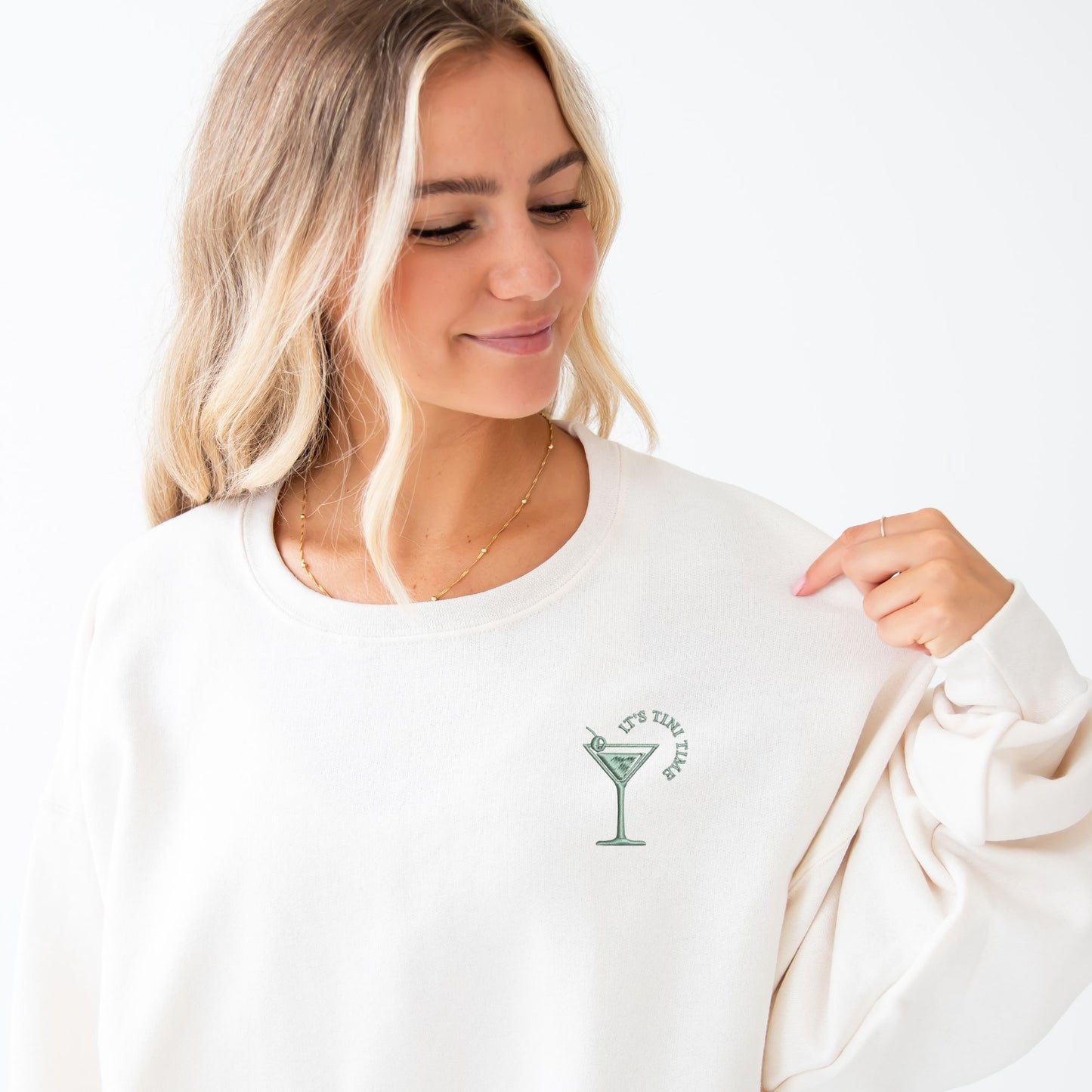 woman wearing an oversized crewneck with a cute tini time embroidered design on the left chest