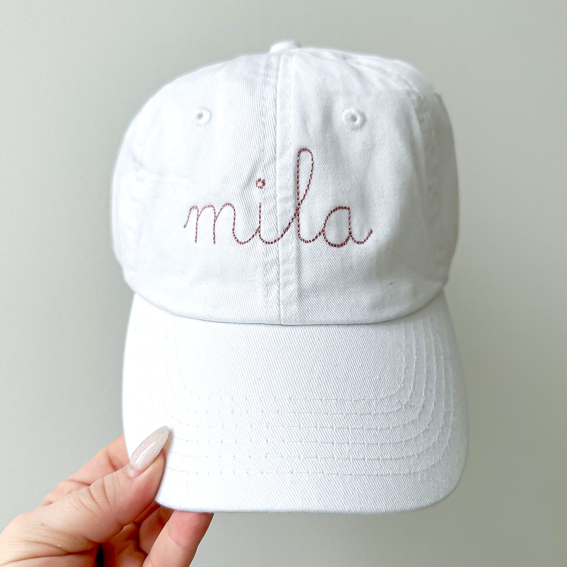 youth white baseball hat with embroidered stitched script name in mauve thread