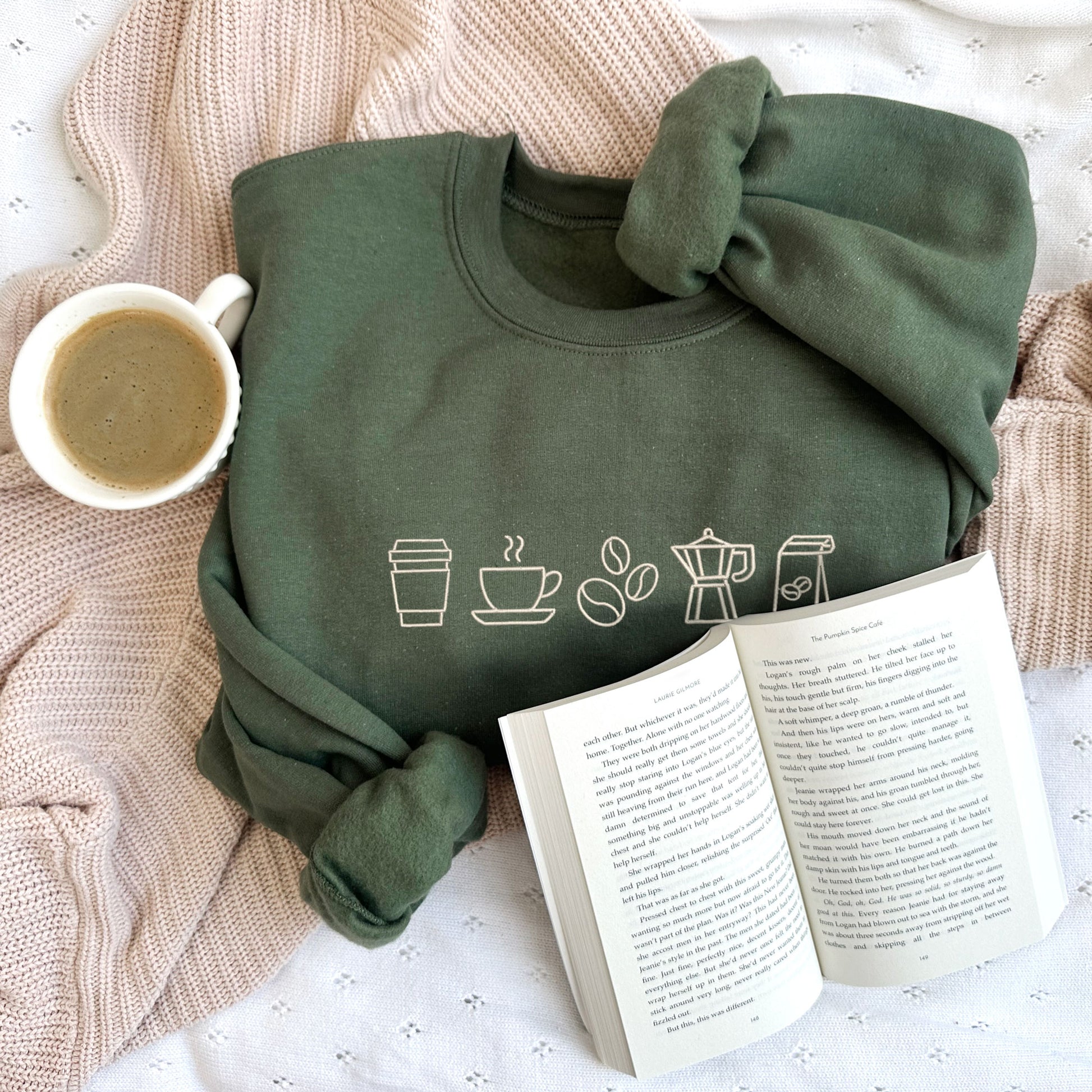 styled flat lay of a military green crewneck sweatshirt with embroidered coffee icons across the chest in natural thread