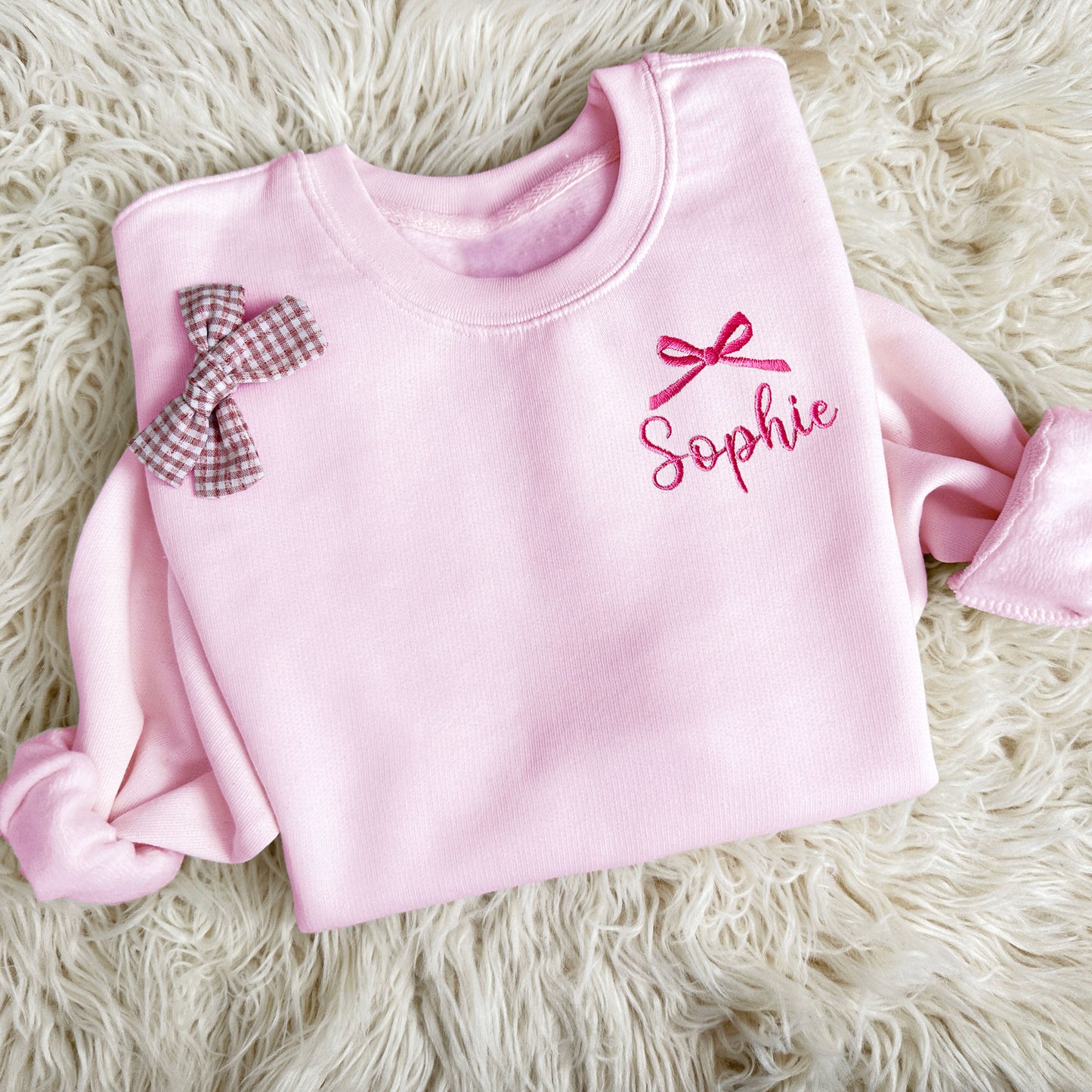 pink youth crewneck sweatshirt with embroidered bow and name design on the left chest in pink thread
