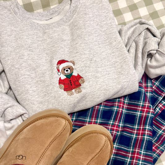 Gray sweatshirt with a teddy bear design on a checkered tablecloth