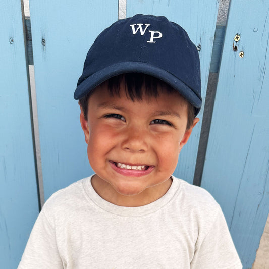 little boy wearing a navy baseball hat with mini embroidered staggered initials 