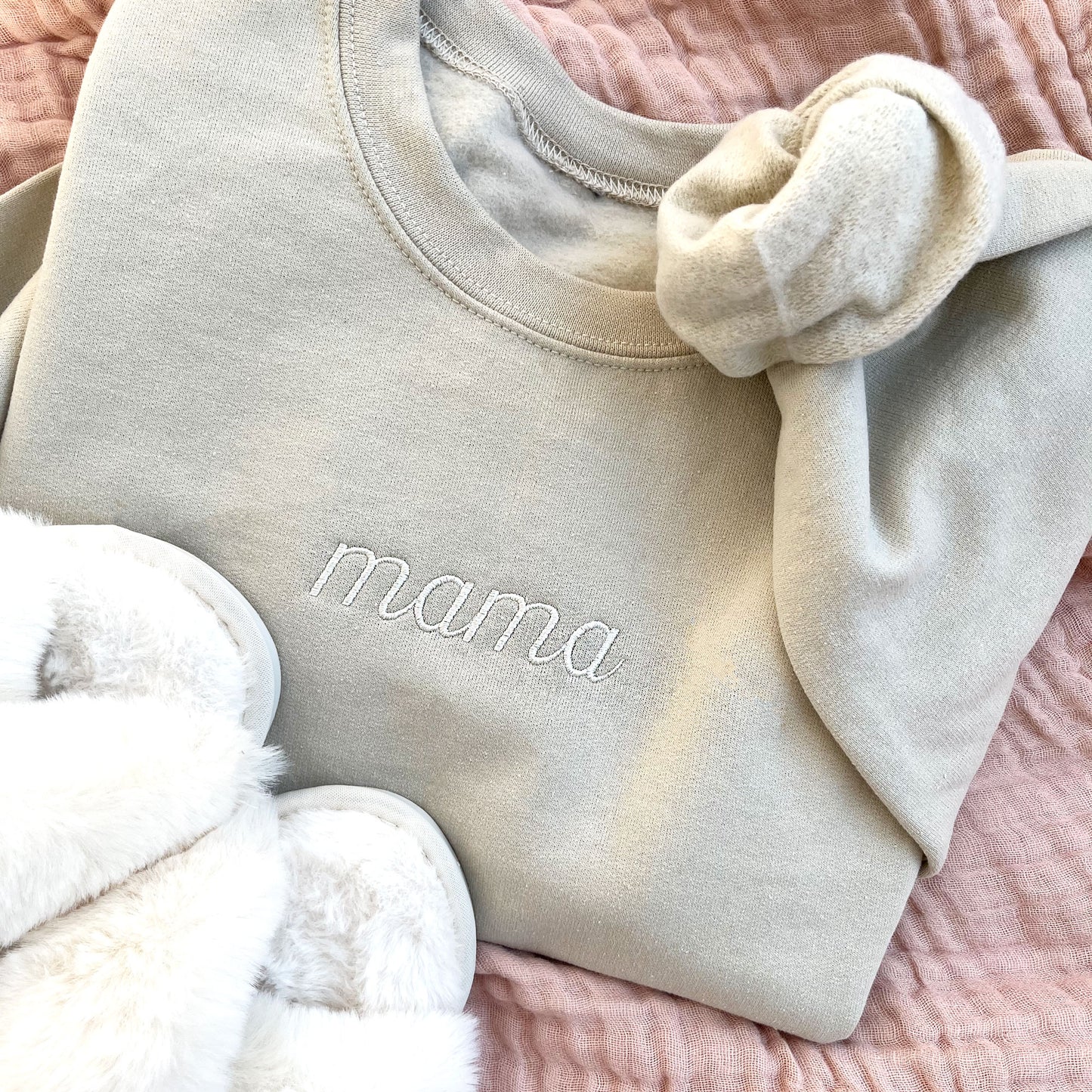 flat lay of a sand crewneck sweatshirt with embroidered mama in script font and natural thread.