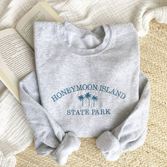 ash crewneck swatshirt with custom embroideered destination arched andd palm trees embroidered in french blue thread