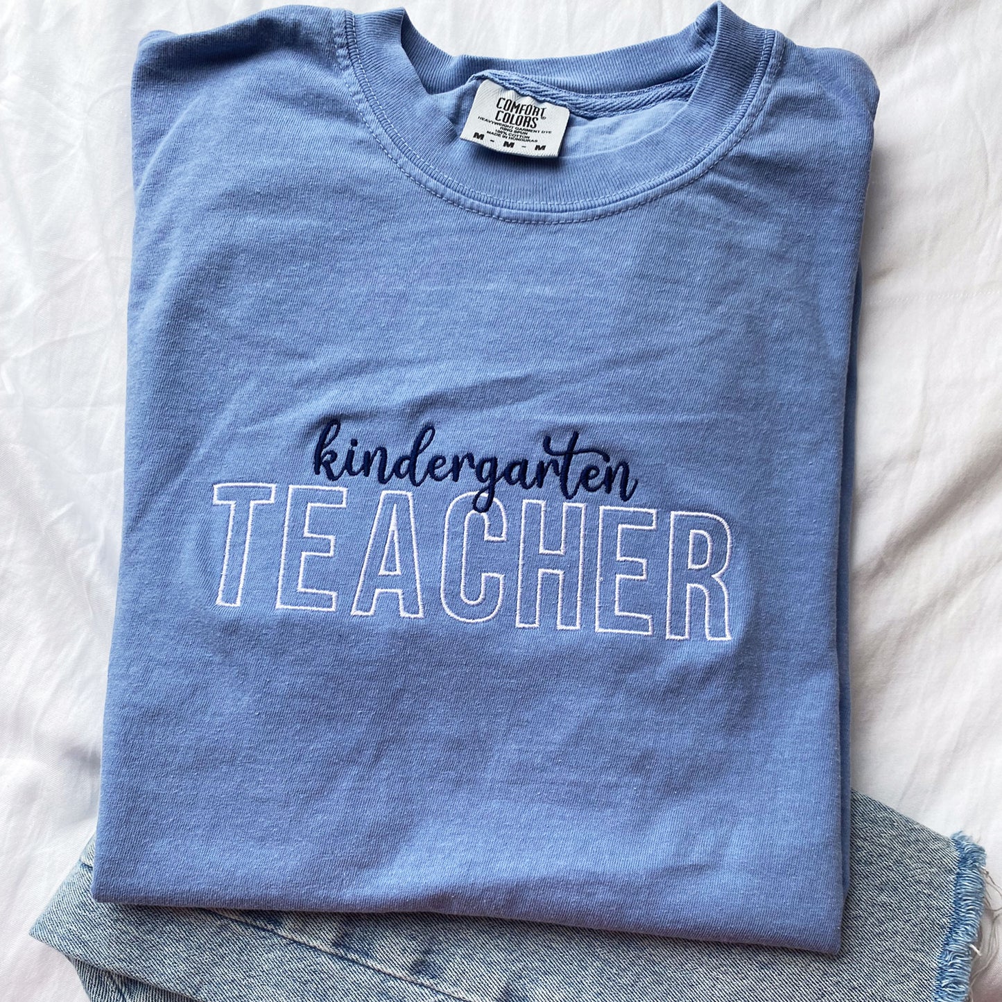 comfort colors t-shirt for teacher with custom embroidered design featuring teacher and name on the center chest