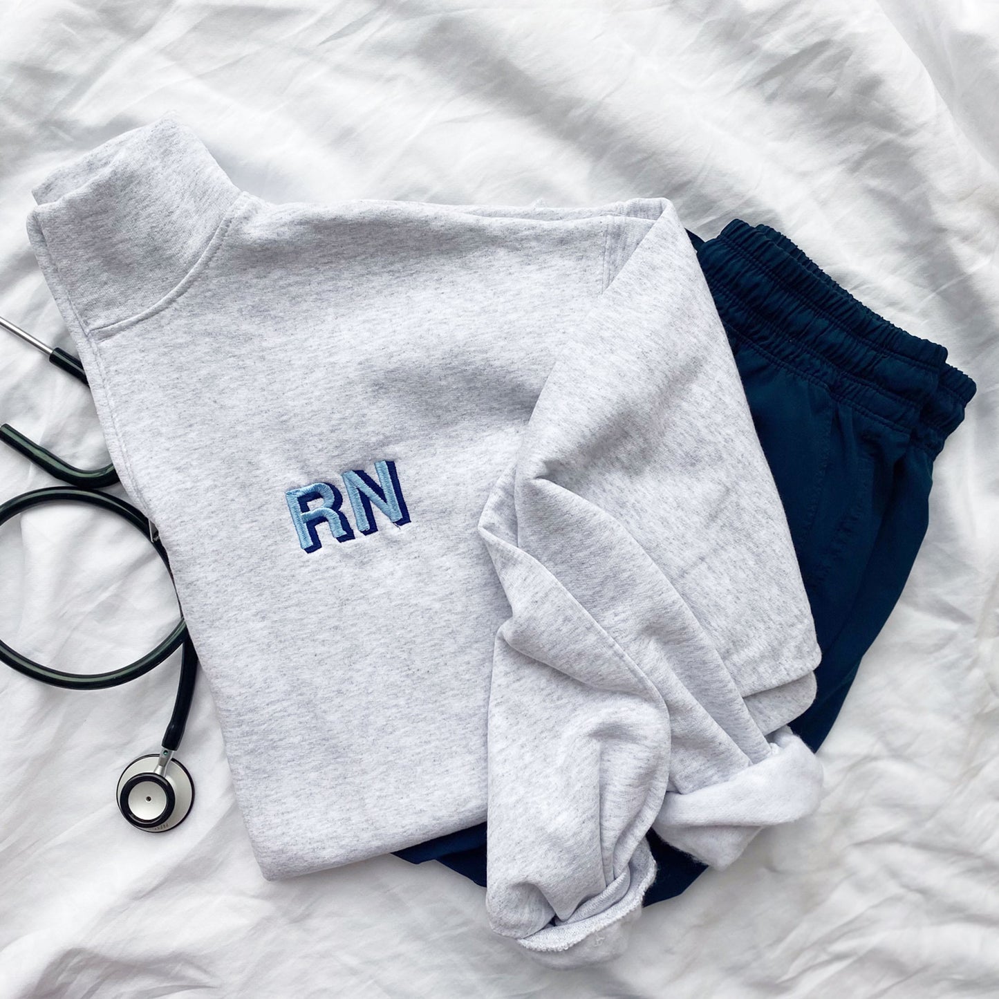 grey quarter zip for nurse with  custom shadow block nurse credentials embroidered on the left chest