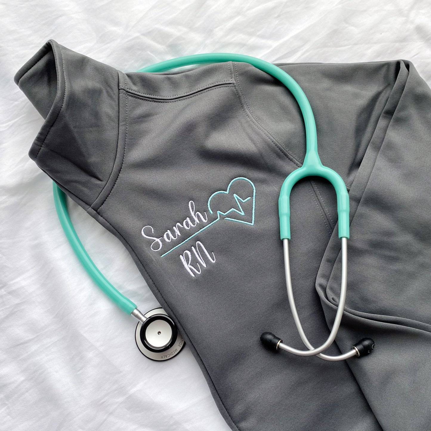 grey cadet collar full zip polyester jacket with a custom name and heartbeat embroidered design on the left chest.