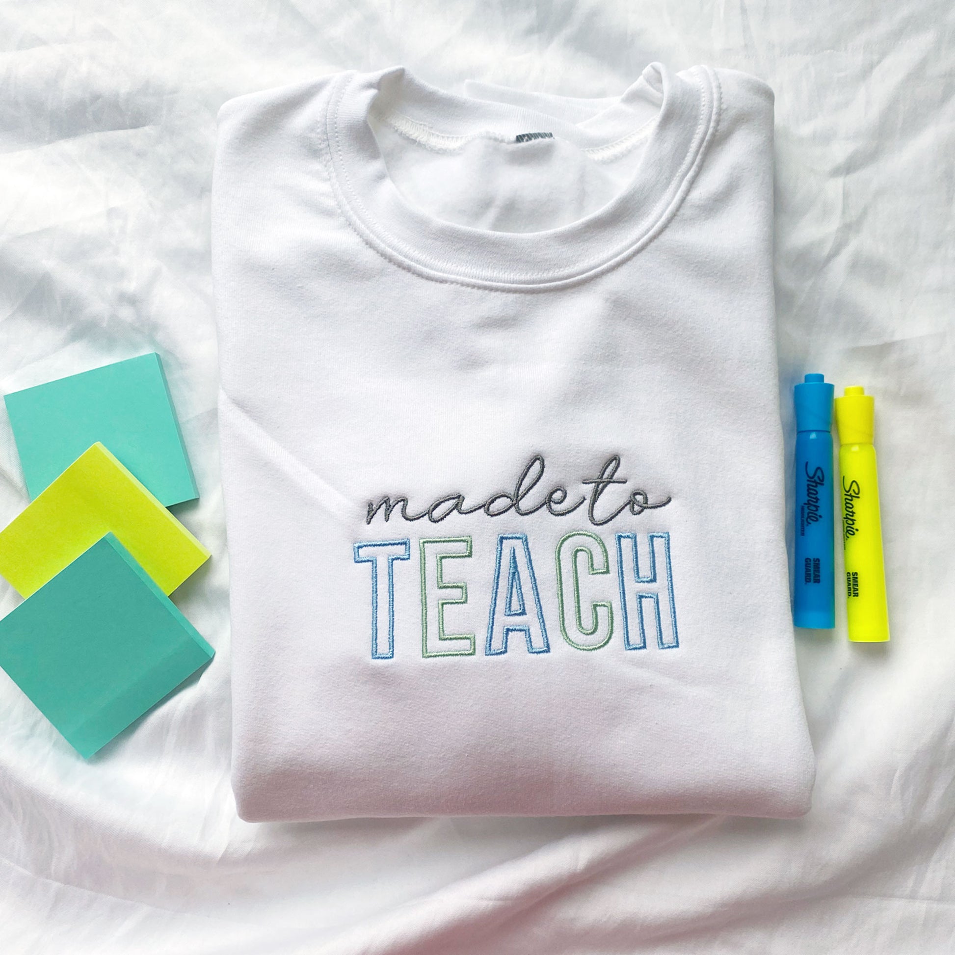 white sweatshirt for teacher with made to teach embroidered across the center chest