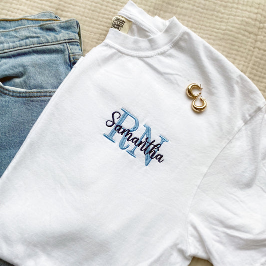 white tee for a nurse featuring a custom embroidered rn/name design on the left chest.