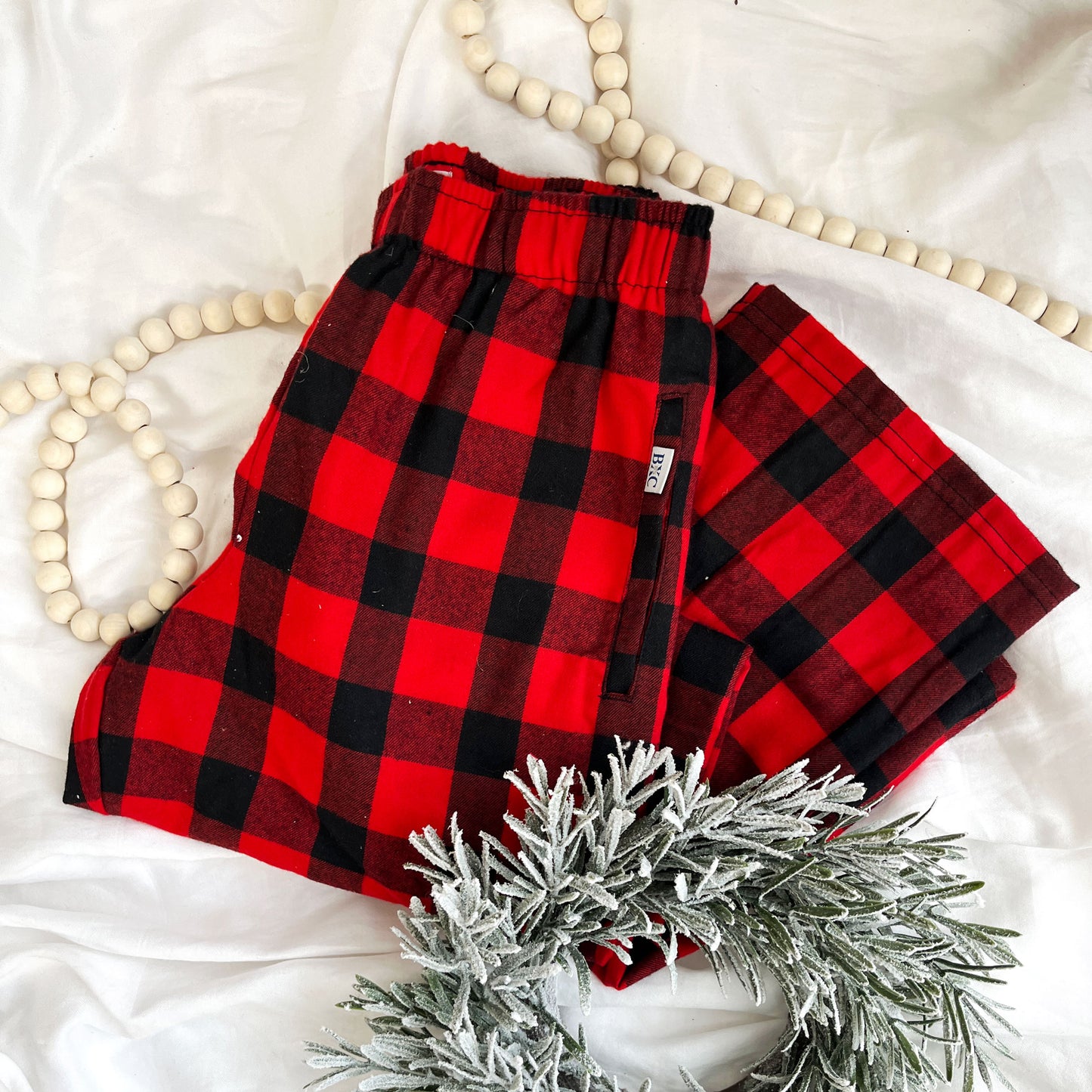 flat lay of red and black buffalo plaid christmas pajama pants