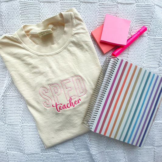 comfort colors ivory tshirt with embroidered sped teacher design in baby pink and pink threads styled with school supplies