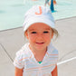 toddler wearing a white baseball cap featuring a single embroidered large initial 