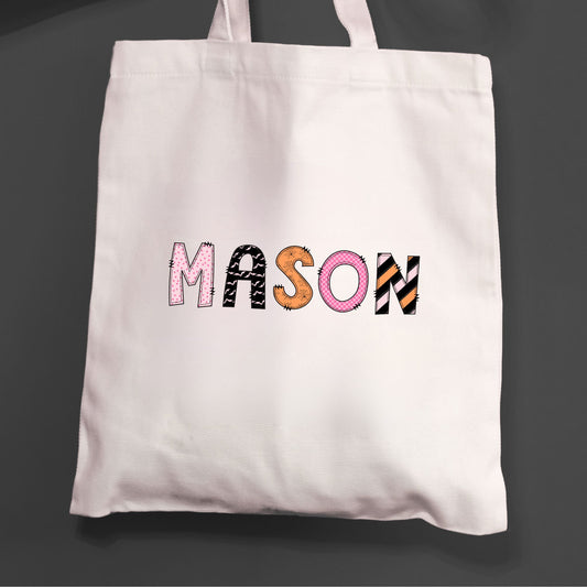 Natural tote bag for trick or treating with a printed custom name design in a mixed pattern font