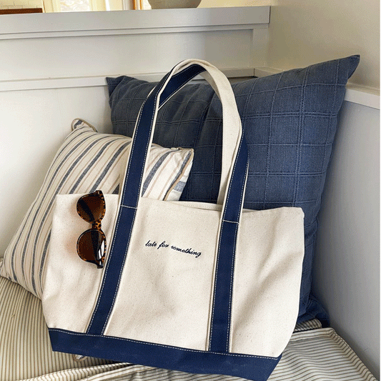 navy trim canvas tote bag with custom mini script embroidery in navy thread