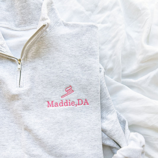 ash quarterzip sweatshirt with pink embroidered tooth brush and name Maddie, DA on the left chest