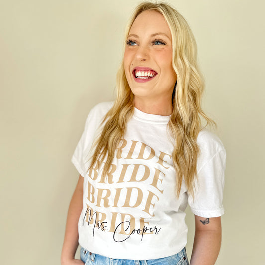 woman wearing a white t-shirt with a cute retro bride print featuring her married name printed along the bottom of the design