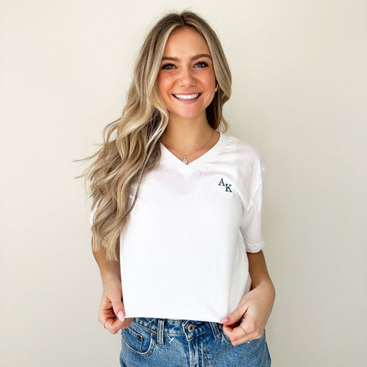 woung woman modeling a size small white v-eck bella and canvas tshirt with mini ak staggered embroidered initials on the left chest in french blue thread