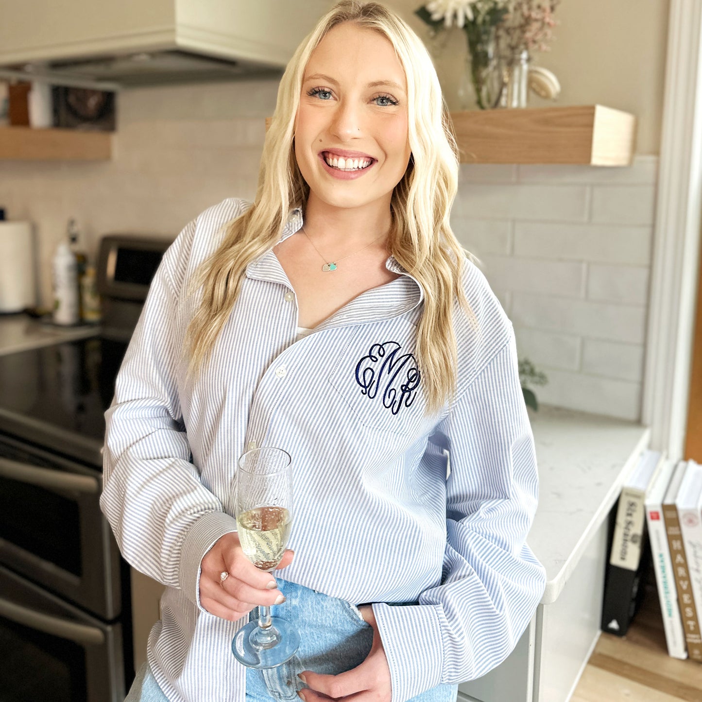 young woman wearing a blue stripe button down with monogram embroidered on the pocket