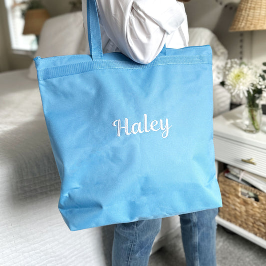 light blue tote bag with full name  embroidered in white thread