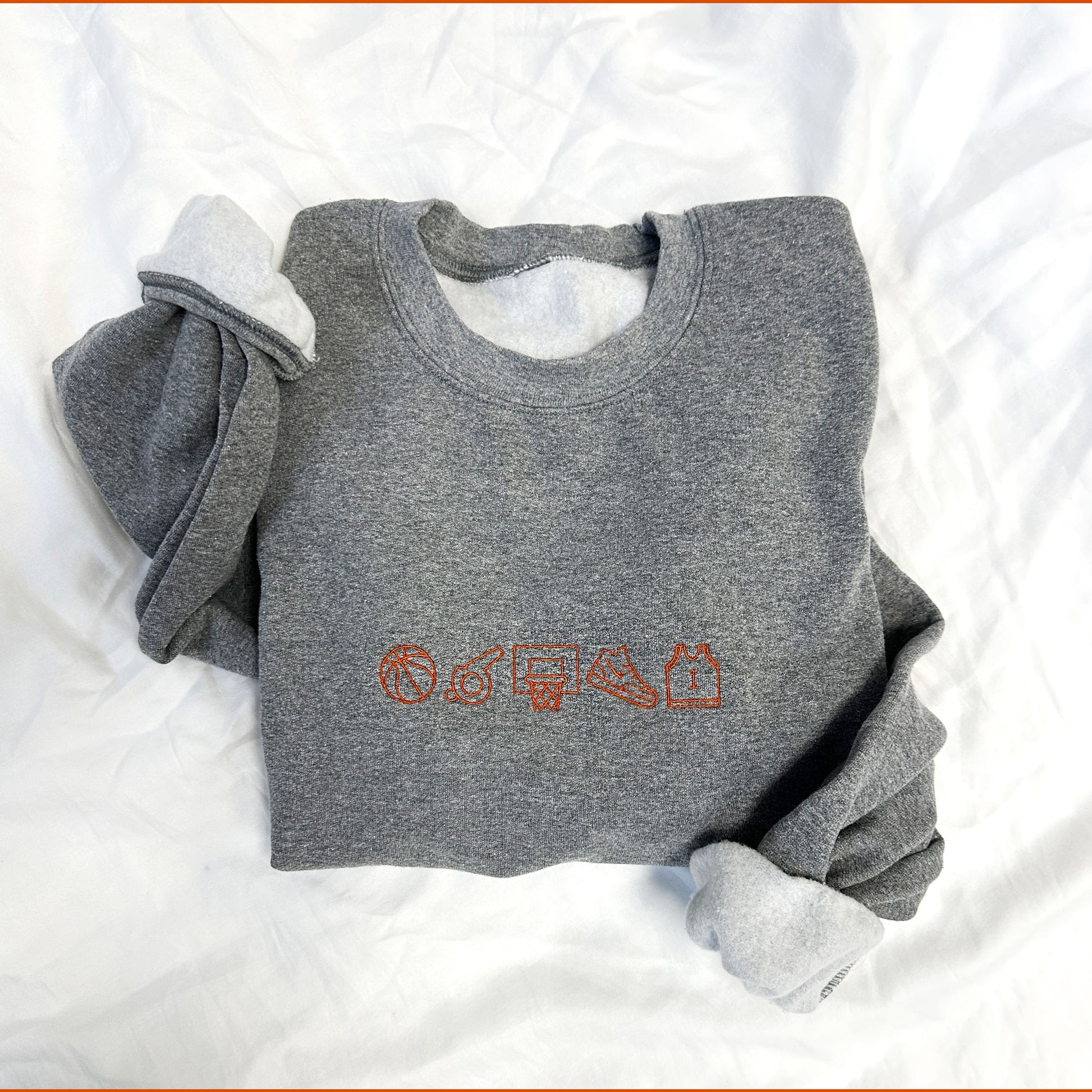 embroidered basketball icon top on a graphite heather crewneck sweatshirt