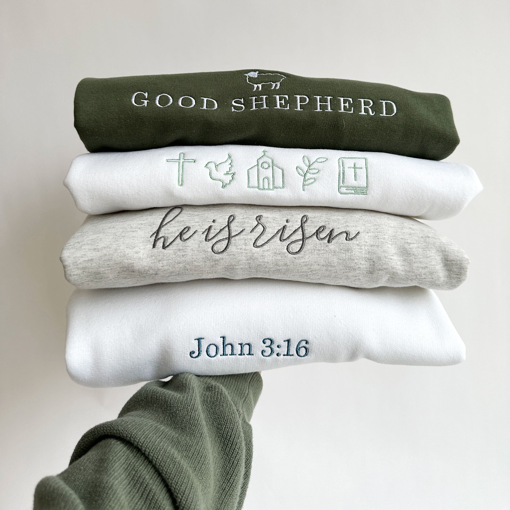 stack of Easter, Christian-based, themed embroidered sweatshirts
