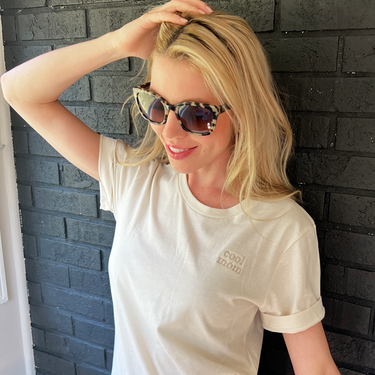 woman wearing a bella and canvas tee with embroidered mini cool mom design