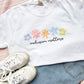 a white t-shirt with a multi-color floral inclusion matters printed design on the front