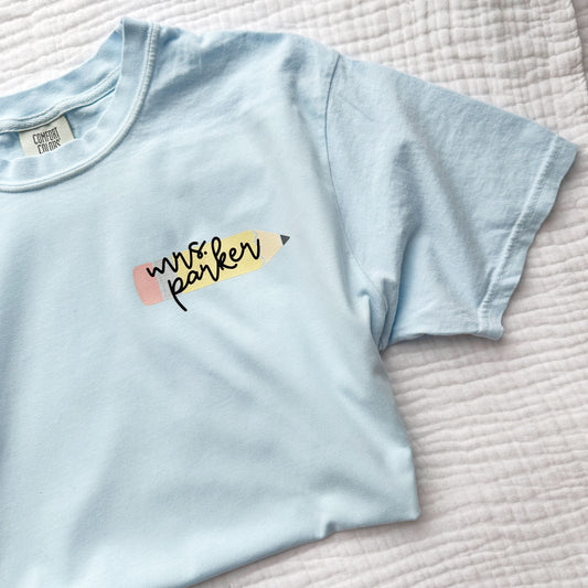 blue t-shirt with a custom pencil/name printed design on the left chest